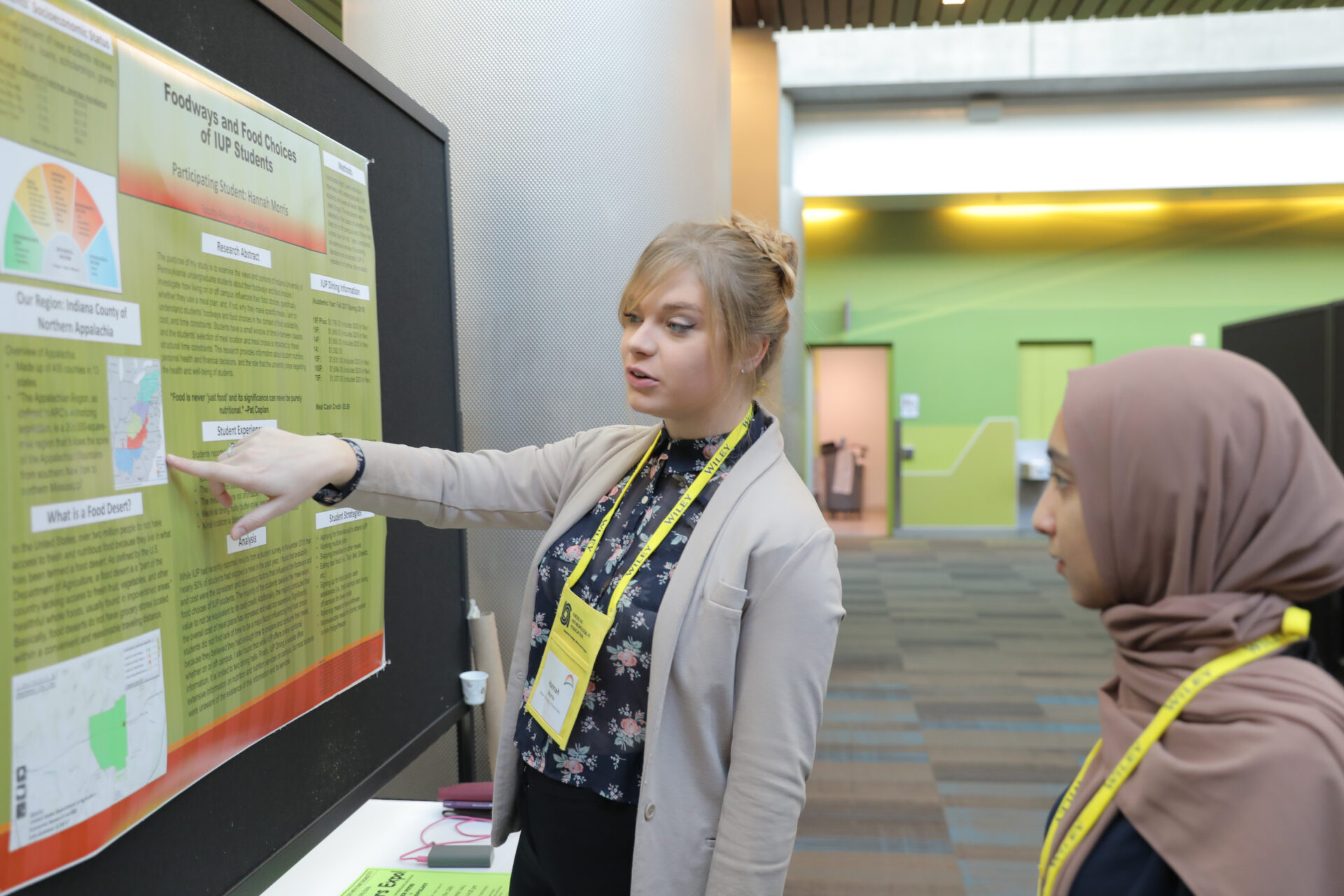 two women reading poster on wall